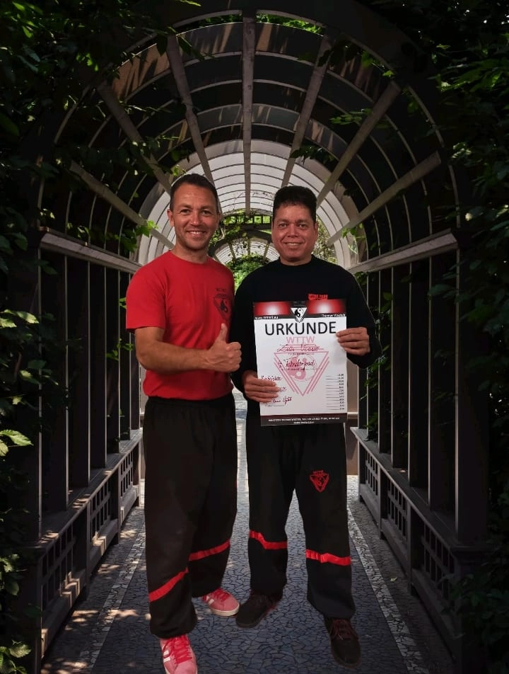 Wyngtsun-Sifu Luis Ocasio und Thomas Wystub stehen zusammen und halten eine Urkunde