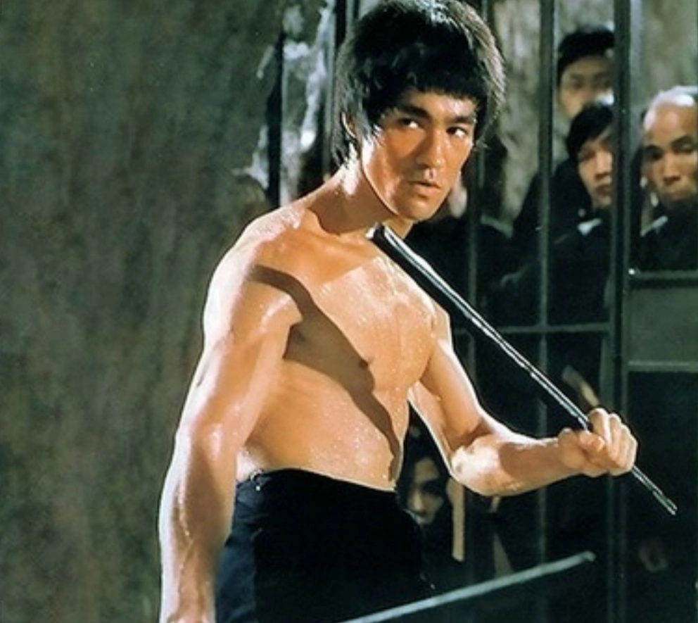 Wyngtsun-Bruce Lee schwingt einen Stab oder Nunchaku